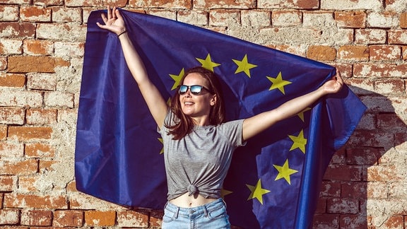 Junge glückliche Frau mit der Flagge der Europäischen Union.