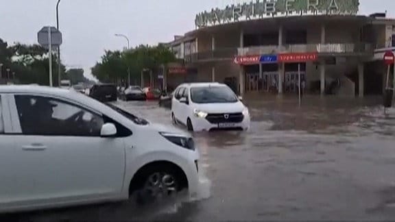 Überflutete Straßen auf Mallorca, Autos fahren durch.