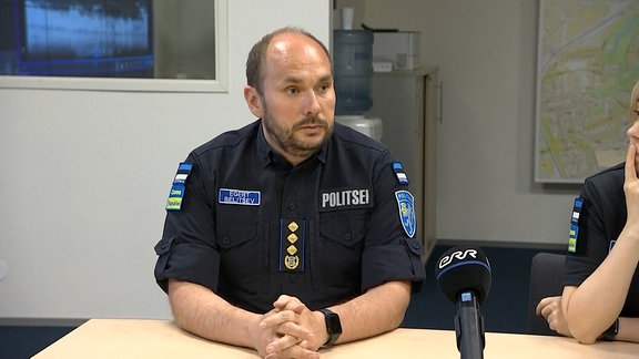 Ein Estnischer Polizist bei einer Pressekonferenz