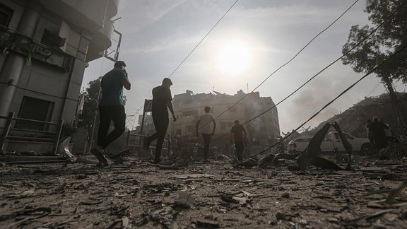 Palästinenser vor einem zerstörten Gebäude