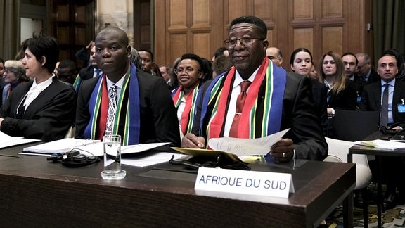 Vusimuzi Madonsela und Ronald Lamola sitzen während der Eröffnung der Anhörung vor dem Internationalen Gerichtshof in der ersten Reihe. 