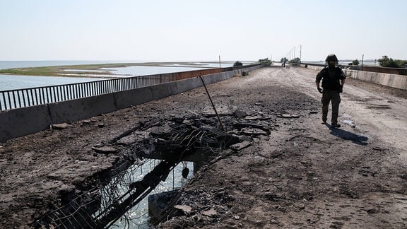 Ein Mitarbeiter des russischen Untersuchungsausschusses besucht eine durch einen ukrainischen Angriff beschädigte Brücke in der Nähe des Dorfes Chongar.