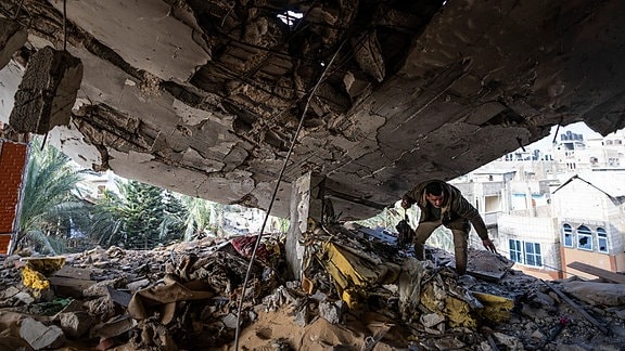 Ein Palästinenser rettet seine Habseligkeiten nach einem israelischen Angriff aus einem zusammengefallenen Haus.