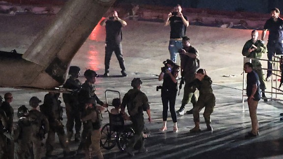 Eine der befreiten Geiseln in einem Rollstuhl rollt nach der Landung auf dem Dach des Ichilov-Krankenhauses aus einem israelischen Militärhubschrauber. 