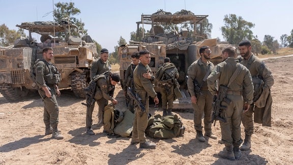 Israelische Soldaten stehen neben Mannschaftstransportern in der Nähe der Grenze zwischen Israel und Gaza, im Süden Israels. 