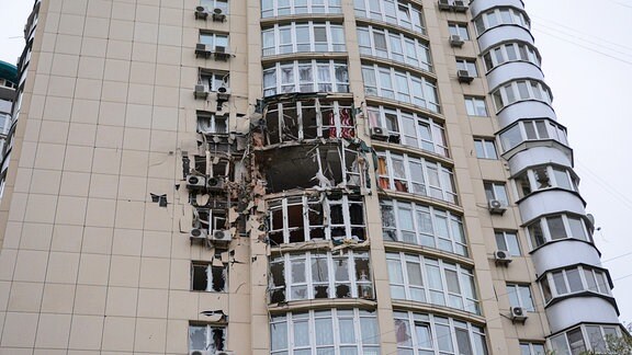 Zerbrochene Fensterscheiben an der beschädigten Fassade eines Wohnhauses in Kiew