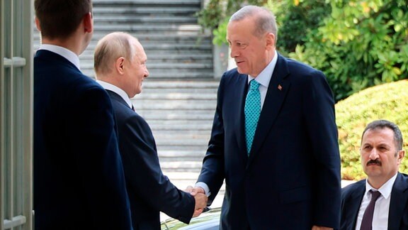 Auf diesem von der staatlichen russischen Nachrichtenagentur Sputnik via AP veröffentlichten Bild begrüÃt Wladimir Putin (2.v.l.), Präsident von Russland, Recep Tayyip Erdogan (2.v.r.), Präsident der Türkei, bei seiner Ankunft. Die Verhandlungen zwischen Russlands Präsident Putin und seinem türkischen Amtskollegen Erdogan über das Getreideabkommen haben begonnen. 