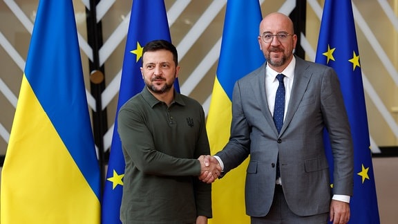 Der Präsident des Europäischen Rates, Charles Michel (r), reicht dem ukrainischen Präsidenten Wolodymyr Selenskyj die Hand