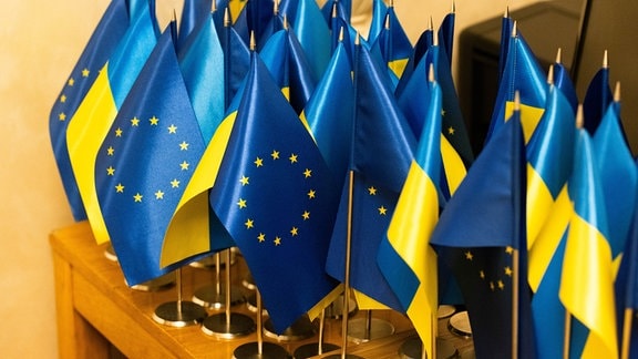 Kleine ukrainische und europäische Flaggen stehen auf einem Tisch