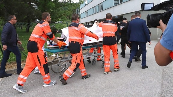 Rettungskräfte bringen den angeschossenen und verletzten slowakischen Ministerpräsidenten Robert Fico auf einer Trage in ein Krankenhaus.