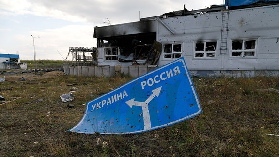 Ein zerschossenes Schild, das die Richtungen zur Ukraine (links) und nach Russland (rechts) anzeigt, aufgenommen am Grenzübergang bei Sudscha an der ukrainisch-russischen Grenze am 17. August 2024 - am elften Tag des ukrainischen Gegenangriffs auf russsichem Gebiet.