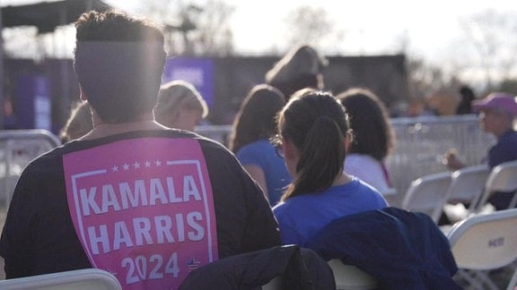 Ein Mann bei einer Wahlkampfveranstaltung von Kamala Harris.