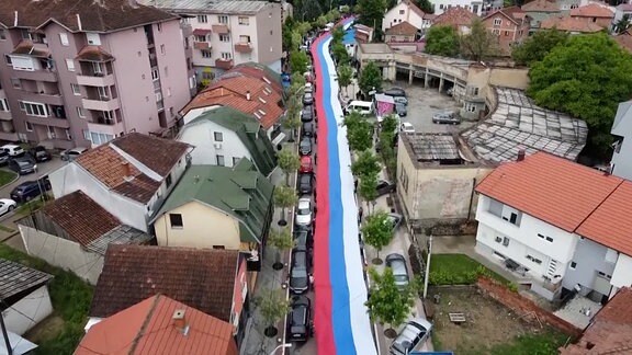 Perspektive aus der Luft: Eine 200 m lange serbische Flagge auf einer Straße ausgerollt. 
