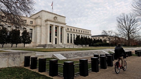 Ein Mann fährt auf einem Fahrrad am Gebäude der US-Notenbank vorbei. 