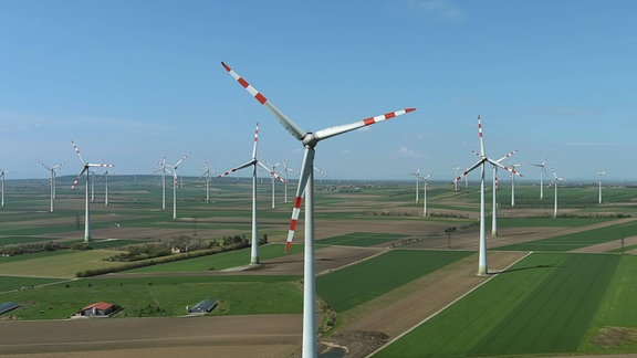 Luftaufnahme von Windturbinen und landwirtschaftlichen Feldern.