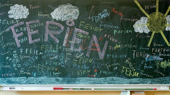 Das Wort "Ferien" steht auf einer Tafel im Klassenzimmer einer Grundschule
