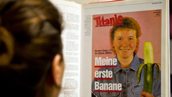 Eine Frau schaut sich das Cover «Zonen-Gaby - meine erste Banane» des Satiremagazins Titanic an. 