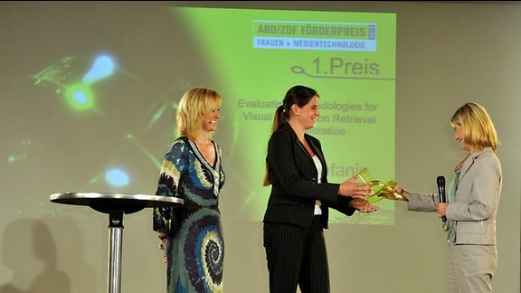 Stefanie Nowak (mi.) erhält den 1.Preis aus der Hand von Bettina Warken (ZDF), re. Daneben MDR-Moderatorin Anja Koebel
