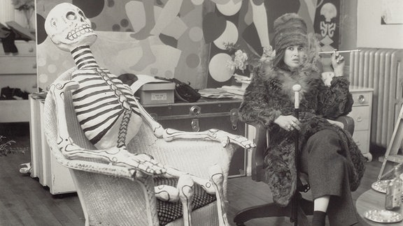 Kiki Kogelnik mit Skelett und Selbstportrait in ihrem Studio in New York, ca. 1965