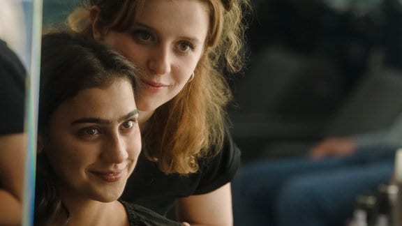 Leonie (Katharina Stark) bedient Guila (Hannah Gharib) im Frisörladen. 