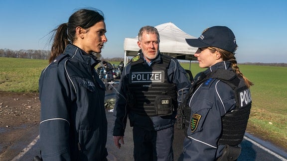 Tatort Dresden "Unter Feuer": v.l.n.r.): Leila Demiray (Aybi Era), Jens Riebold (Andreas Lust), Anna Stade (Paula Kroh) - Die drei Kollegen von der Wache Lebtal besprechen die Vorkommnisse bei der Verkehrskontrolle, die aus dem Ruder gelaufen ist.