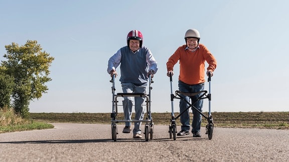 Zwei Senioren mit Helm und Rollator