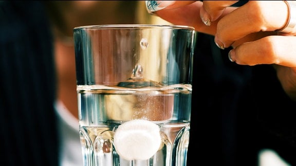 Eine lösliche Tablette in einem Wasserglas.