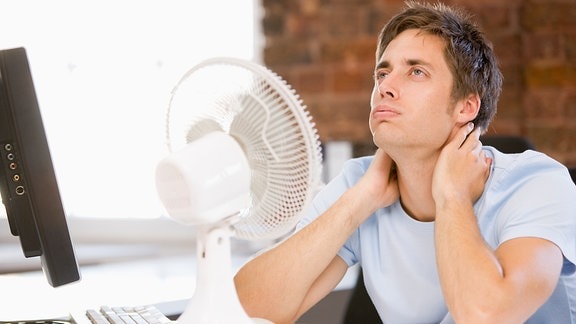 Ein Mann sitzt vor einem Ventilator