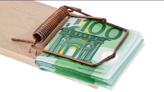 ein Bündel 100-Euro-Scheine ist in einer Mausefalle eingeklemmt
