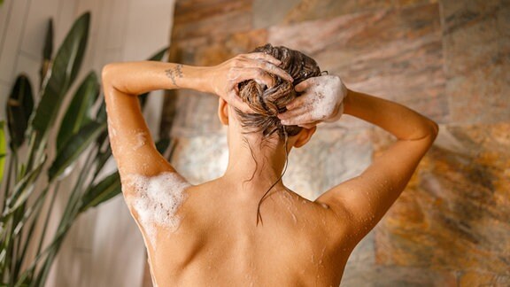 Eine Frau wäscht sich die Haare.