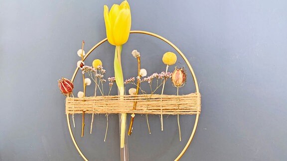 Ein mit Blumen geschmückter goldener Osterkranz