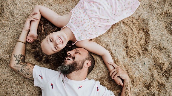 Ein Mann und ein Mädchen im Sand