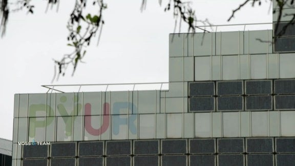 Eine Häuserfassade trägt den Firmennamen "PYUR".