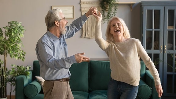 Ein Ehepaar tanzt im Wohnzimmer