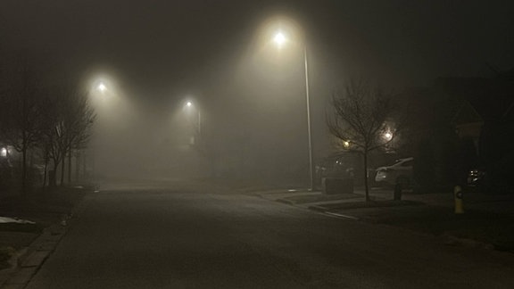 Laternen beleuchten in der Dunkelheit eine Straße