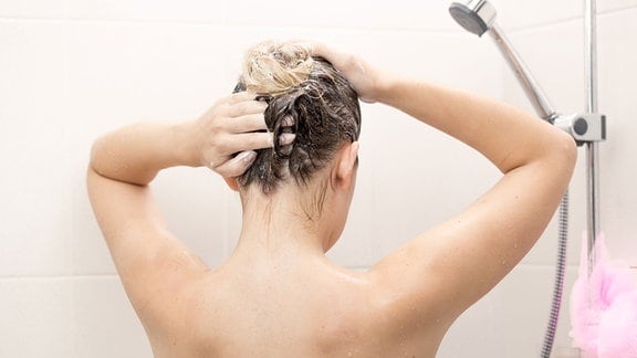 Frau unter der Dusche bei der Haarwäsche