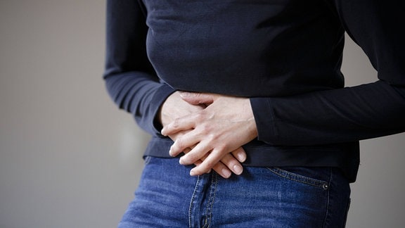Symbolfoto Magenschmerzen. Eine Frau haelt ihre Haende vor den schmerzenden Bauch