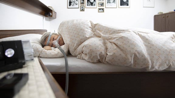Frau schlaeft mit einem Luftbefeuchter bei Schlafapnoe