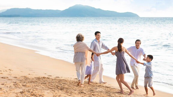 Ein chinesische Familie tanzt am Strand.