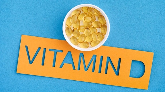 Vitaminkapseln liegen in einem Schälchen über dem Schriftzug "Vitamin D".
