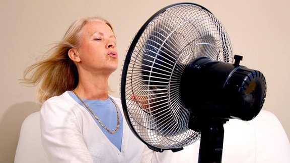 Eine Frau vor einem Ventilator