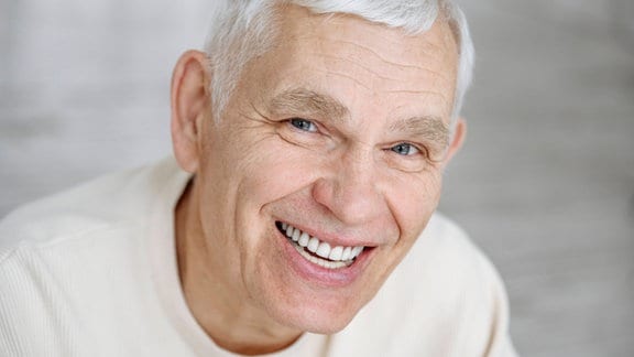 Ein Mann mit weiß-grauen Haaren.