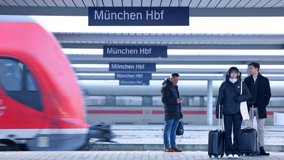 Hauptbahnhof München, Reisende warten am Bahnsteig auf Zug.