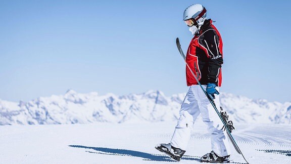 Urlauber in Skioutfit auf verschneitem Berg.
