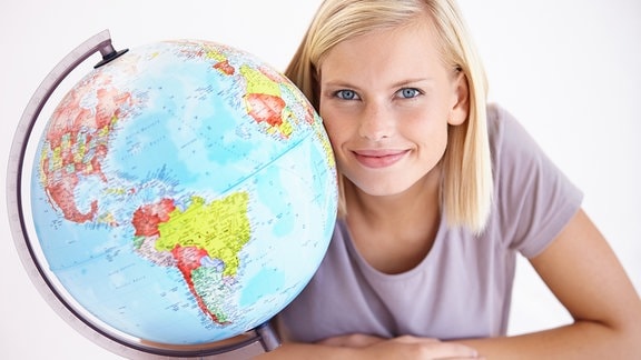 Eine junge Frau neben einem Globus