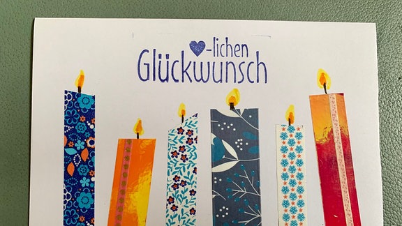 Eine Glückwunschkarte mit bunten Kerzen