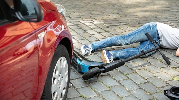Symbolbild - Bewusstloser Mann liegt auf der Straße nach Unfall mit Elektro-Roller 
