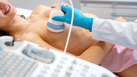 Eine Frau wird per Ultraschall auf Brustkrebs untersucht.