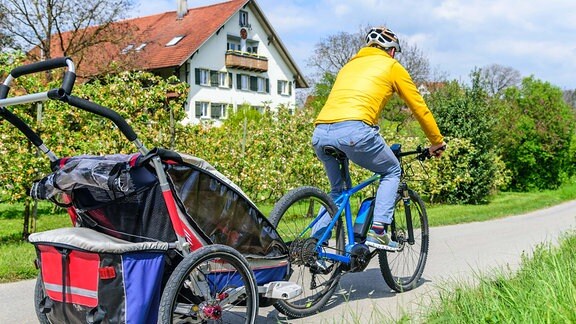 Ein Radfahrer mit einem Fahrradanhänger für Kinder
