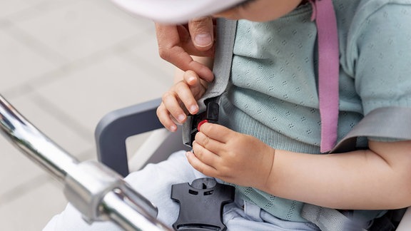 Ein Kind in einem Kindersitz auf einem Fahrrad